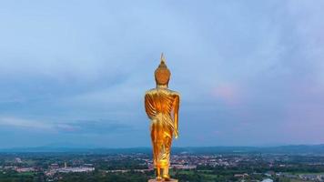 time lapse-vy av den välsignande buddhastatyn med färgglad himmel vid wat phra that khao noia i nan-provinsen i thailand. video