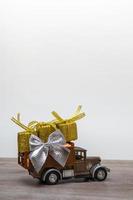 Retro car with gifts on a colored background. Vertical format copy space. Festive concept photo