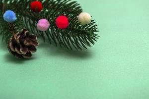 Christmas card. Flatley branches of a Christmas tree colorful fur toys on a green background. photo