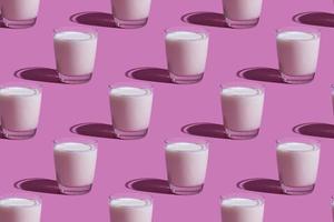 día mundial de la leche. patrón sobre un fondo rosa. un vaso de leche. patrón. foto