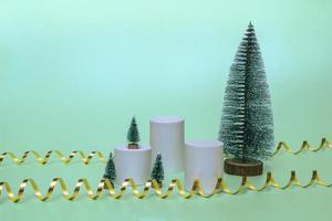 maquetas de podios para cosméticos con árboles de navidad sobre un fondo navideño con cintas doradas. de cerca foto