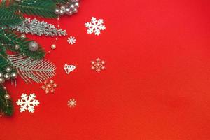 Top view of a flat lay of Christmas decorations on a red background. Concept postcard, announcement, banner. With copy space photo