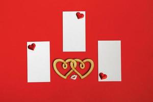 tarjetas en blanco con corazones sobre un fondo rojo. concepto del día de san valentín. foto