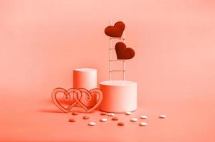 Podium with wooden stairs and hearts on a red background, monochrome. Celebrating Valentine's Day copy space. photo