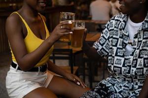 Young afro couple in a night club toasting with beer. photo