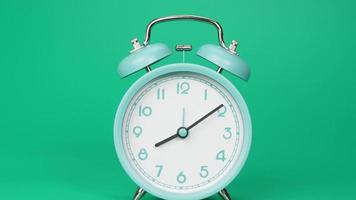 lapso de tiempo, reloj despertador moderno azul. un viaje de tiempo que pasa en un día. sobre el fondo verde.