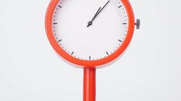 Moving camera, Orange  clockon the table the passage of time. Tells the time quickly of the long hand. On the white background. video