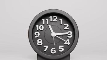 Nahaufnahme, Zeitraffer, moderne graue Uhr, die den Lauf der Zeit zeigt. zusammenarbeiten, die Hand zeigt die Zeit an. auf grauem Hintergrund. video