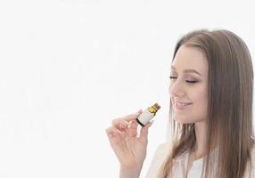 smiling woman sniffs eucaliptus oil for immunity boost and respiratory health. althernative medicine concept. copy space for text