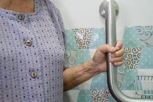 Asian senior or elderly old lady woman patient use toilet bathroom handle security in nursing hospital ward, healthy strong medical concept. photo