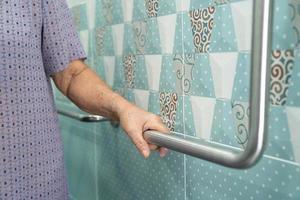 Asian senior or elderly old lady woman patient use toilet bathroom handle security in nursing hospital ward, healthy strong medical concept. photo