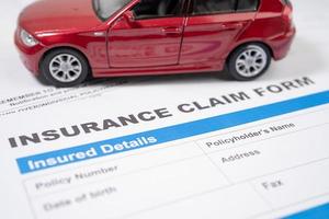 Red car on Insurance  claim accident car form, Car loan, insurance and leasing time concepts. photo
