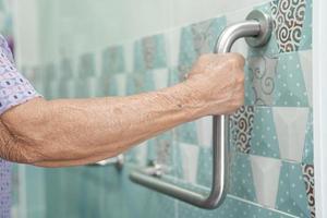 Asian senior or elderly old lady woman patient use toilet bathroom handle security in nursing hospital ward, healthy strong medical concept. photo