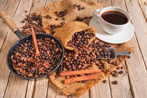 Coffee cup and beans on old woodden table photo