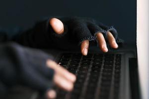 hacker hand stealing data from laptop top down photo