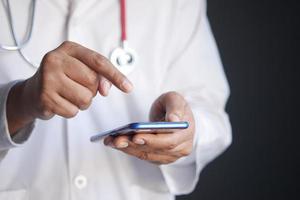 doctor in white coat using a smartphone. photo