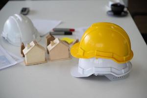Casco de casco en el escritorio del ingeniero proyecto de construcción de viviendas foto