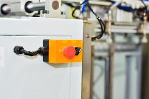 Botón de emergencia para controlar el funcionamiento de la máquina en la industria manufacturera. foto