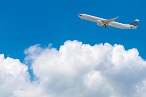 Avión comercial volando sobre un cielo azul brillante y nubes blancas. diseño elegante con espacio de copia para el concepto de viaje.