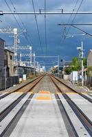 tren vía férrea con cables de alimentación en la estación de tren local en Japón. foto