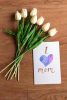 Watercolour card with i love mom word and flower on wooden floor