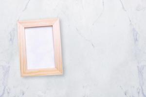 Top view of nature wooden photo frame on marble table. Elegant Design with copy space for placement your text, mock up your product.