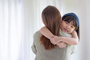 Asian mother make love with warm hug her cute daughter at home photo