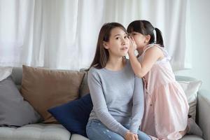 Madre asiática siente felicidad mientras juega a su linda hija con amor y cuidado en casa
