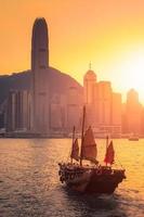 Barco de turistas tradicionales de Hong Kong para el servicio turístico en el puerto de Victoria con vistas a la ciudad de fondo al atardecer, vista desde el lado de Kowloon en Hong Kong foto