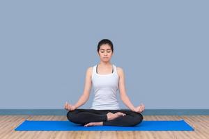La mujer asiática mantiene la calma y medita mientras practica yoga para explorar la paz interior. el yoga y la meditación tienen buenos beneficios para la salud. concepto de fotografía para el deporte y el estilo de vida saludable. foto