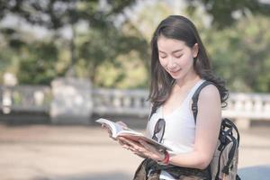 Hermosa mujer turista asiática leyendo la guía de viajes en busca de lugares turísticos para turistas. viajes de vacaciones en verano. foto
