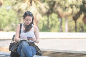 Beautiful asian tourist woman reading the travel guide book searching for for tourists sightseeing spot. Vacation travel in summer. photo