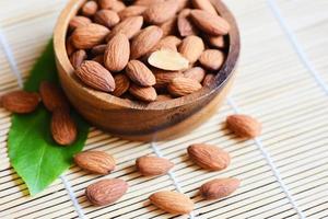 Almonds nuts on wooden bowl, Close up roasted almond nuts natural protein food and for snack photo