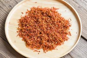 Dried safflower for herbal tea on tray wooden background, dry safflower petals, Saffron substitute