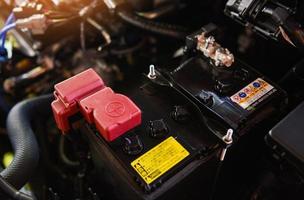 closeup new battery car in engine room - mechanic car battery photo