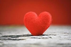 Tarjeta de vacaciones día de San Valentín corazón rojo sobre madera vieja para el concepto de filantropía - corazones sobre un fondo de madera donar ayudar a dar amor cuidar foto