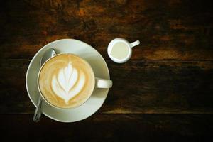 coffee cup of cappuccino with latte art on wooden background photo