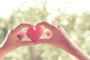 corazón en mano para el concepto de filantropía - mujer sosteniendo un corazón rojo en las manos para el día de San Valentín o donar ayuda a dar amor calidez cuidar