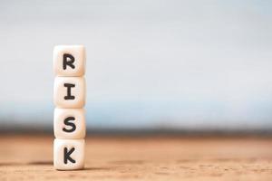 Risk concept with block risk stacked on wooden table background photo