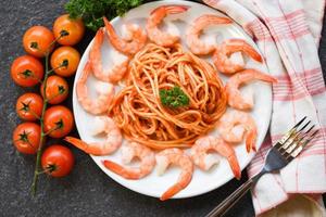 Spaghetti bolognese italian pasta with shrimp prawn served on white plate with tomato parsley in the restaurant italian food and menu concept - spaghetti seafood photo