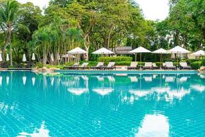 Umbrella and chair around swimming pool in hotel resort photo