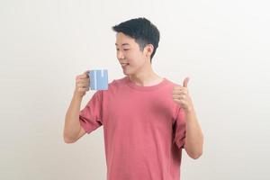 young Asian man holding coffee cup photo