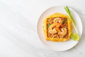 Thai stir fried noodles with shrimps and egg wrap photo