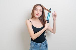 portrait beautiful Asian woman using hair curler or curling iron photo