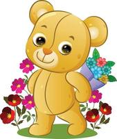 The happy teddy bear is holding a bucket of flowers behind his back in the garden vector