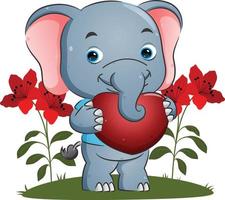 el dulce elefante sostiene un gran corazón con la cara feliz para San Valentín vector