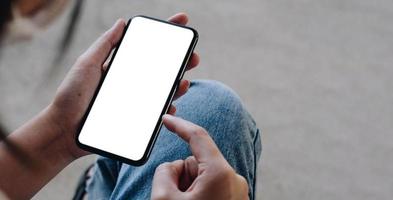 Mockup picture of business woman hands holding smart phone with white blank screen in modern place photo