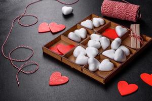 hermoso fondo con corazones blancos y rojos sobre una mesa oscura foto