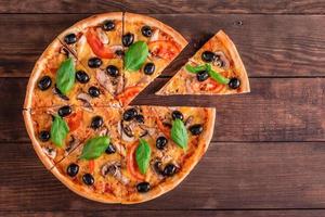 Delicious pizza with olives and chicken on wooden table