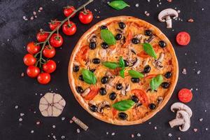 Deliciosa pizza con aceitunas y pollo en mesa de madera foto